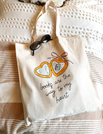book tote bag cute tote bag, heart locket tote bag book lovers tote, canvas tote bag with pink bow books, book bag for women, women's book bag laying on bed neutral colors aesthetic book reader gift 