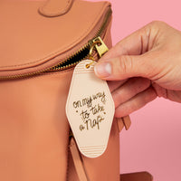 on my way to take a nap in beige style with gold hand draw lettering design clipped on a boho styled backpack