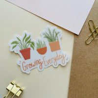 growing everyday potted plants clear sticker. 3 potted plants lined up with the phrase "growing everyday" below it written in hand lettered font