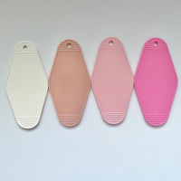 four blank hotel keychains for customization, one beige, one light pink, one white, and one bright pink