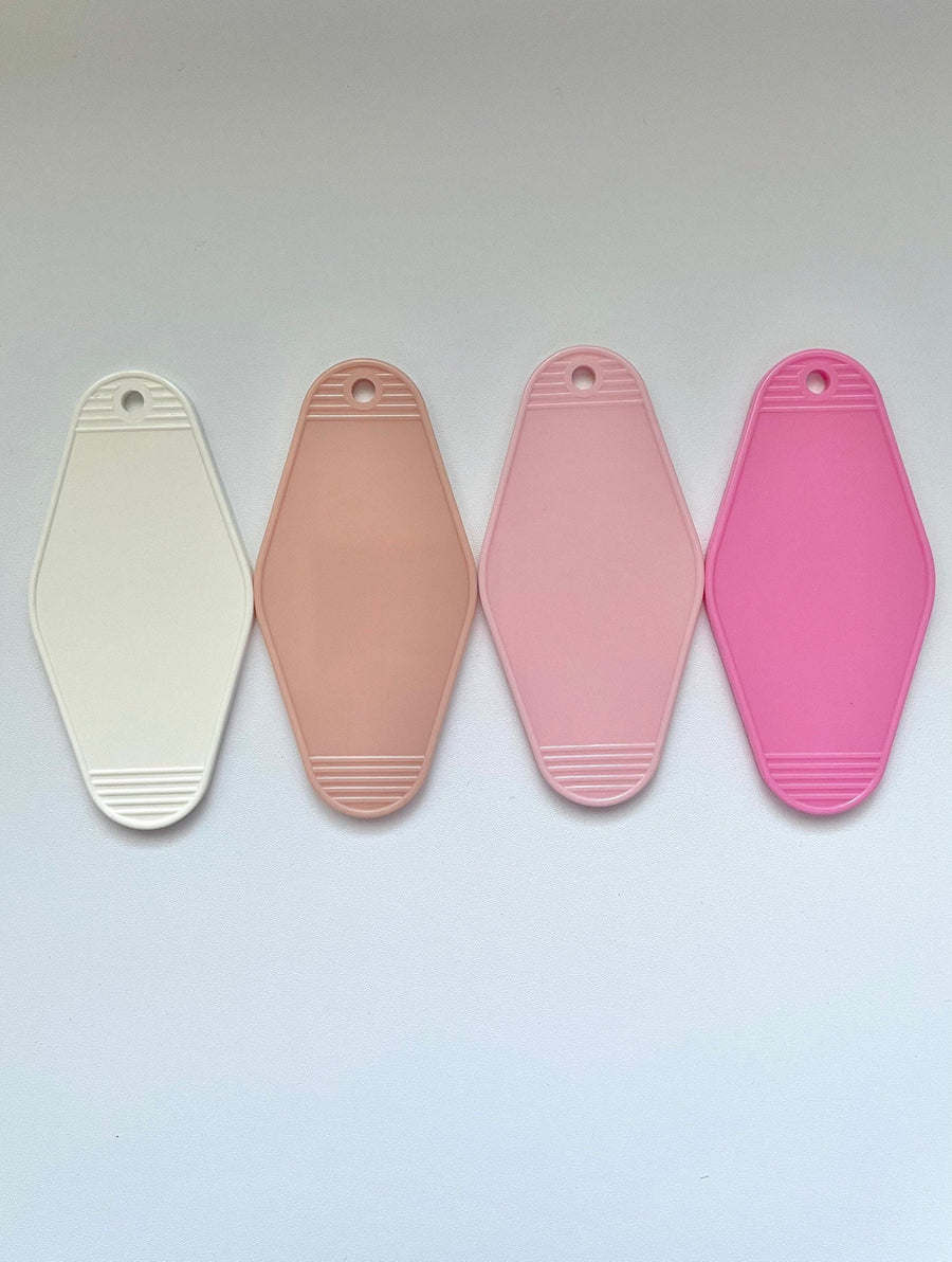 four blank hotel keychains for customization, one beige, one light pink, one white, and one bright pink